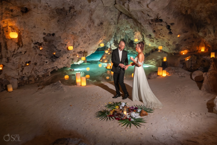 Turquoise underground lagoon illuminated by candlelight inside a Riviera Maya cenote.