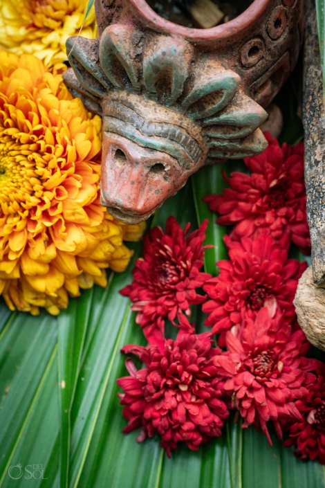 Mayan-inspired ceremony details with flowers and candles.