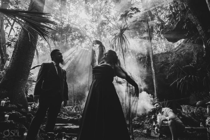 Cenote wedding Ceremony Bride in a black wedding dress beneath jungle light.