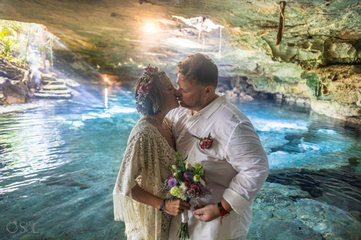 First kiss Cenote wedding photography beneath natural light beams in a Riviera Maya cave