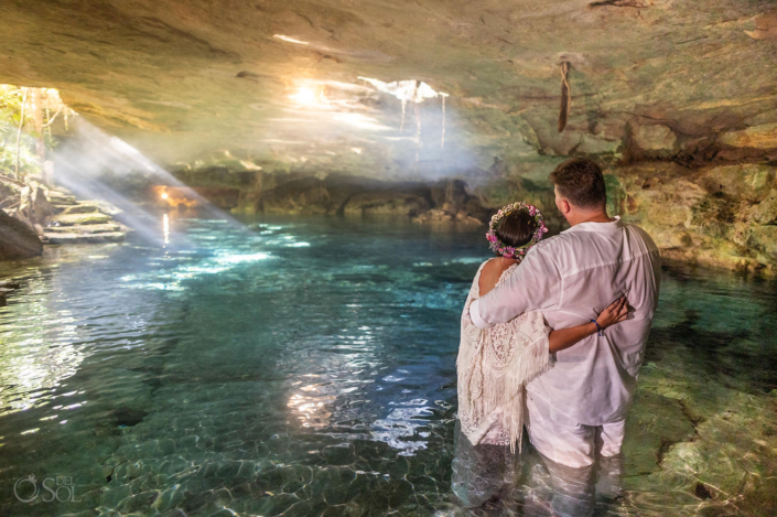 Intimate newlywed portrait inside a natural cathedral cenote in Mexico