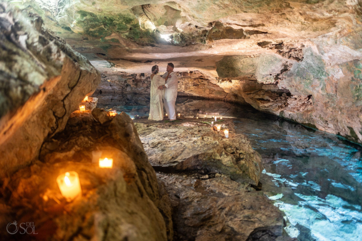 Candlelit cenote wedding portrait surrounded by limestone, crystal clear blue water and natural light